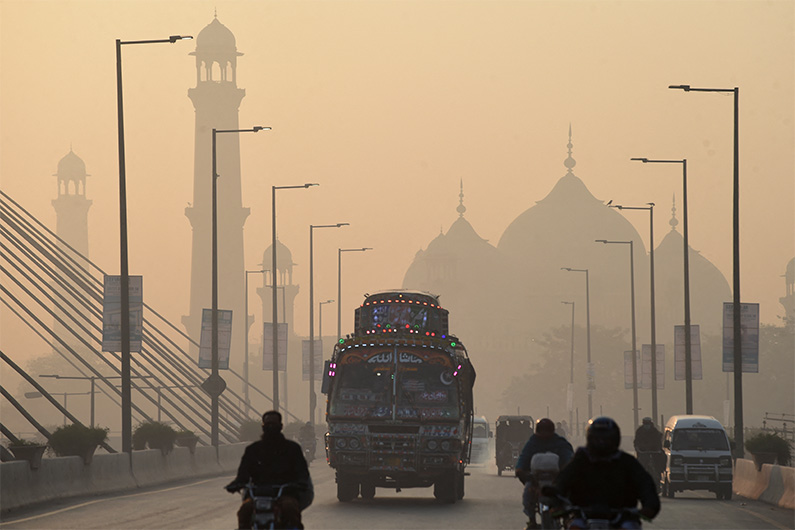 Vehicles make their way amid heavy smog conditions in Lahore on November 17, 2021. (AFP)