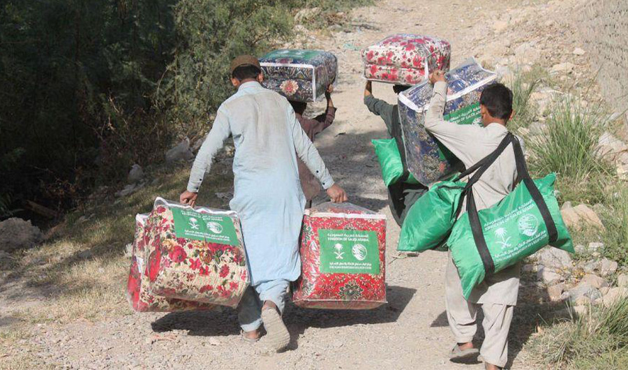 People carrying winter aid provided by King Salman Humanitarian Aid and Relief Center (KSRelief) in an earthquake-hit district in Pakistan's southwestern Balochistan province on Nov 20, 2021. (SPA)