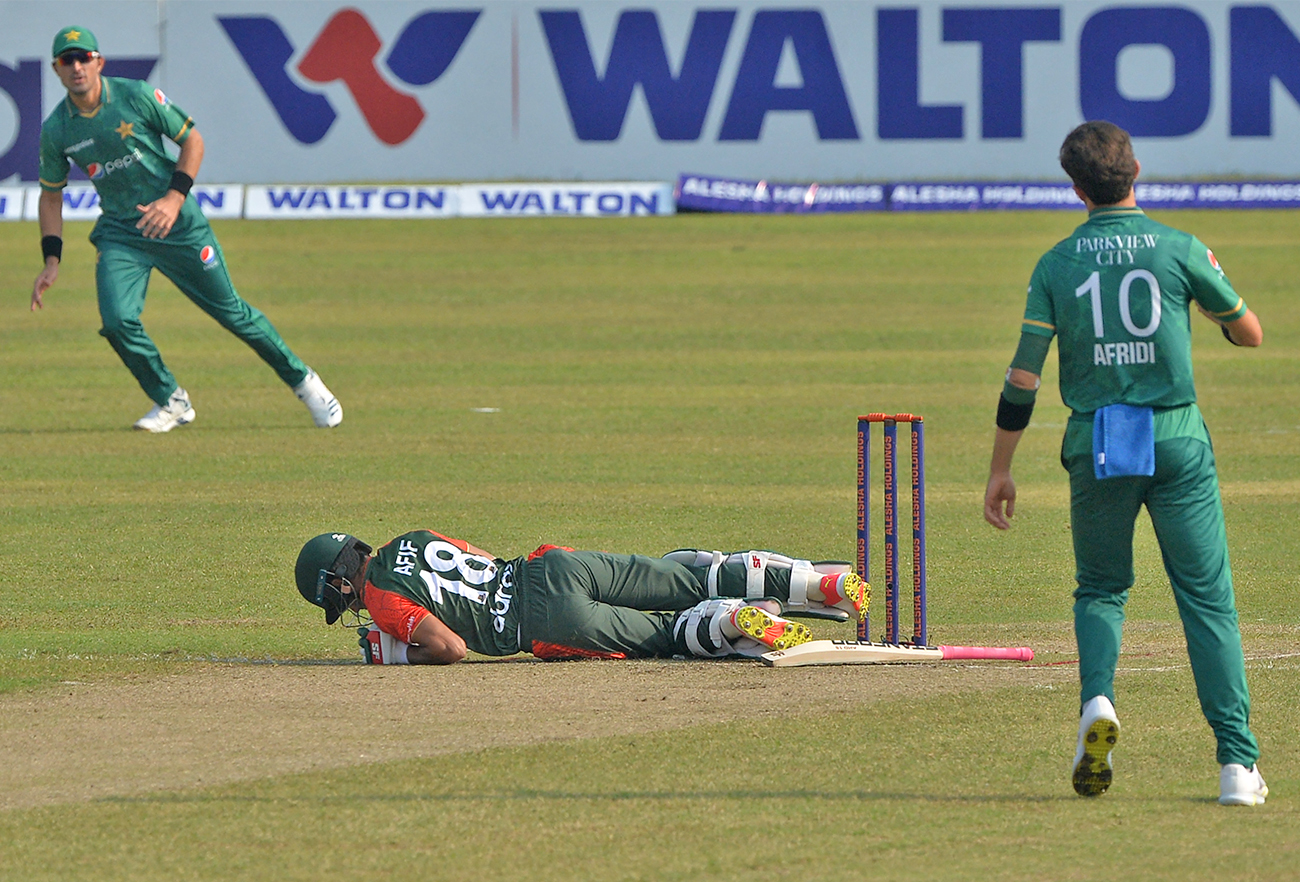 Bangladesh's Afif Hossain (C) lies on the ground after he was hit by the ball as Pakistan's Shaheen Shah Afridi (R) watches during the second T20I cricket match at the Sher-e-Bangla National Cricket Stadium in Dhaka on November 20, 2021. (AFP)