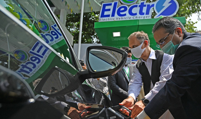 Pakistan's energy minister Omar Ayub Khan and Prime Minister's advisor on Petroleum Nadeem Babar charge an electric car during the inauguration ceremony of country's first electric vehicle charging station, in Islamabad on July 29, 2020. (AFP/File)