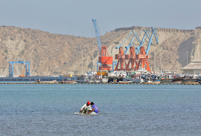 Boys sit on a piece of styrofoam sheet as they search for crabs in front of the Gwadar port, Pakistan, on April 11, 2017. (REUTERS/File)