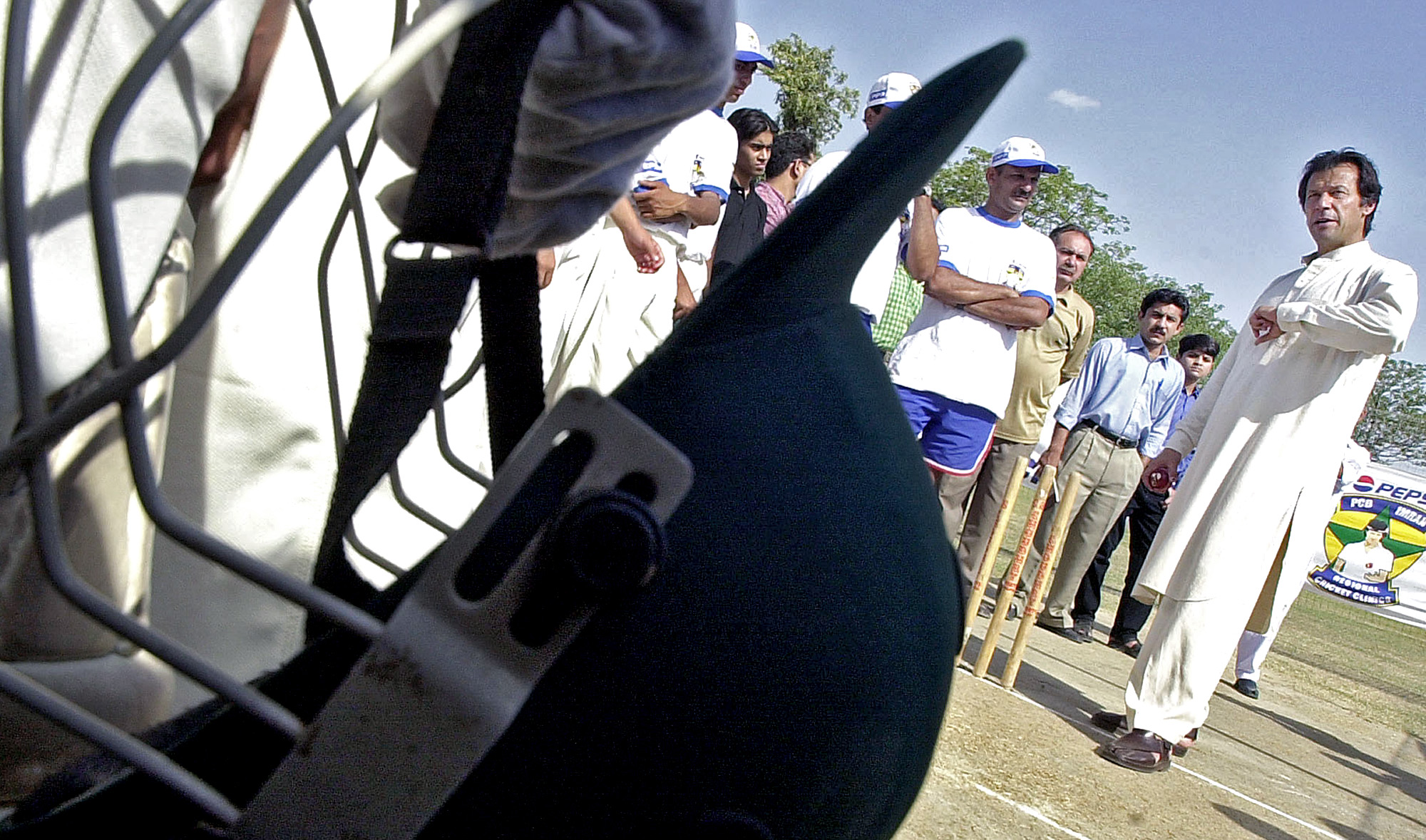 Pakistan cricket legend Imran Khan, right, gives tips to his students during a session conducted under the auspices of the Pakistan Cricket Board and soft drink giants Pepsi in Rawalpindi, 20 June 2003. (AFP/File)