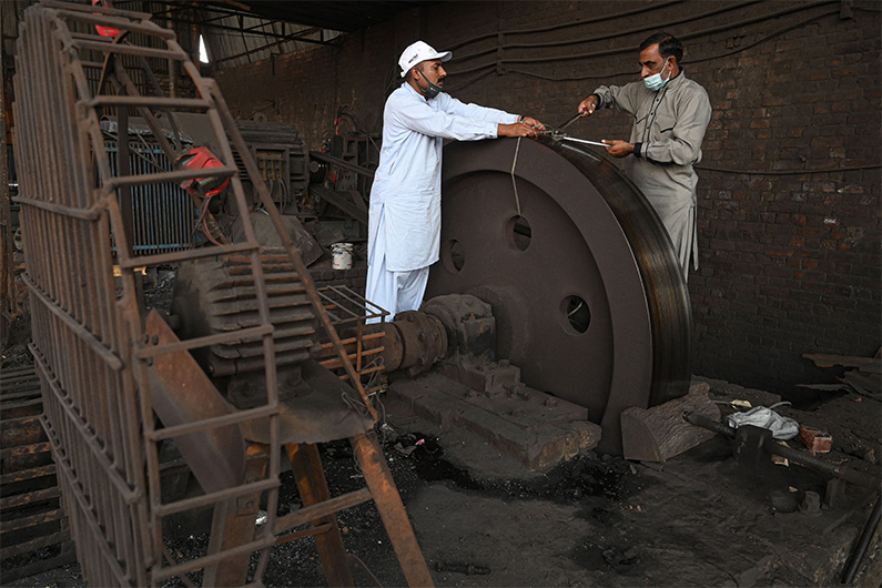 This picture taken on November 19, 2021 officials of the environment department Anti-Smog Squad (ASS) preparing to seal a steel factory for violating pollution norms in Lahore. (AFP)