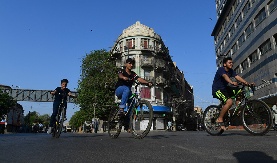 Pakistani youths ride their bicycles along a street in Karachi on May 2, 2021. (AFP/ File)