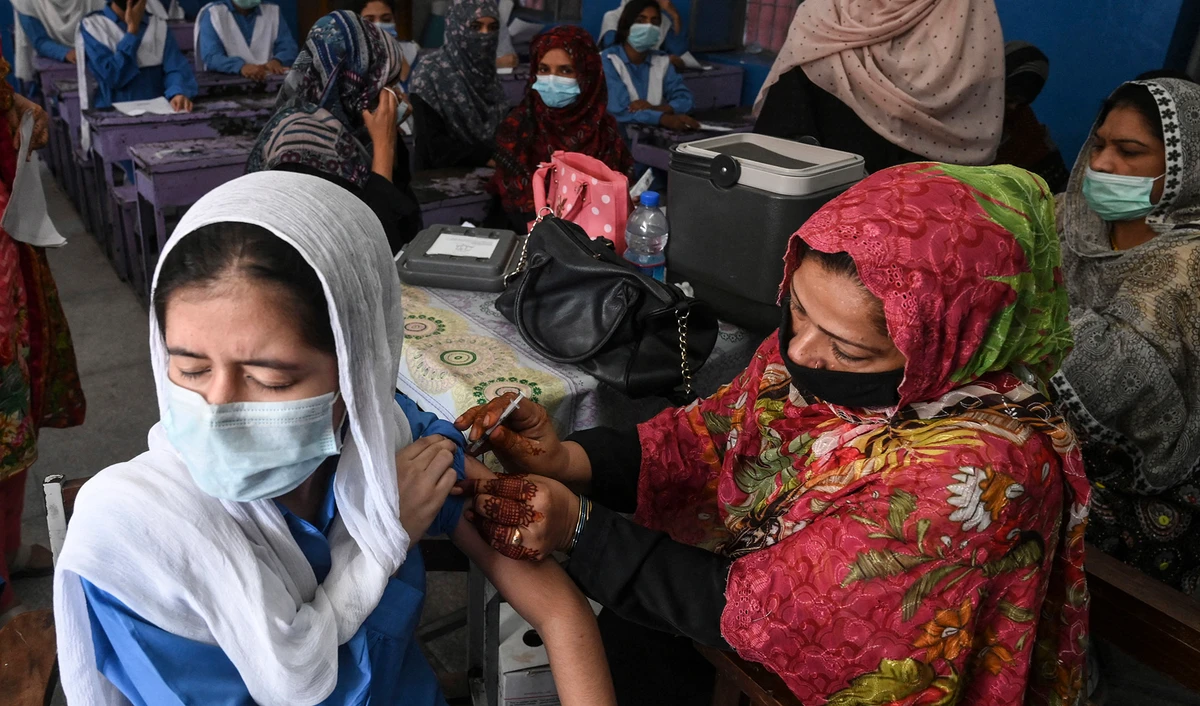 A health worker inoculates a student with a dose of Pfizer vaccine against the Covid-19 coronavirus at a school in Lahore, Pakistan on October 5, 2021. (AFP/File)