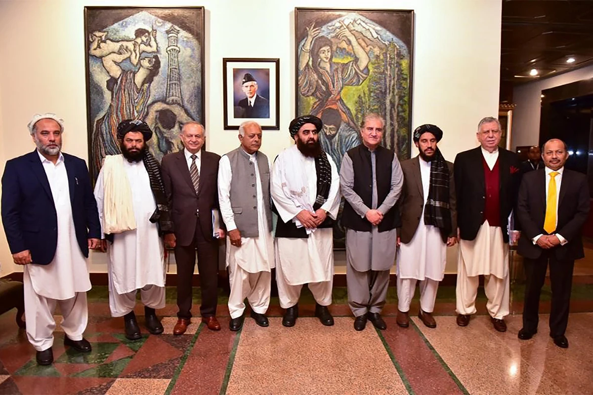 This handout photograph taken and released by Pakistan's Ministry of Foreign Affairs on November 11, 2021, shows Afghanistan's acting Foreign Minister Amir Khan Muttaqi (C), Pakistan's Foreign Minister Shah Mahmood Qureshi (4R), Pakistan Minister for Aviation Ghulam Sarwar Khan (4L), Pakistan's Prime Minister commerce adviser Abdul Razak Dawood (3L) pose for picture along with other delegation members at Pakistan's Foreign Ministry, in Islamabad, Pakistan. (AFP)