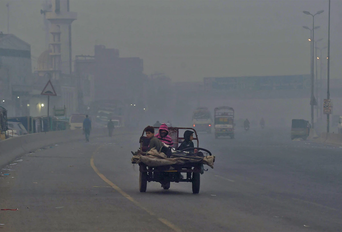 People commute along a street amid heavy smoggy conditions in Lahore, Pakistan, on November 18, 2021. (AFP)