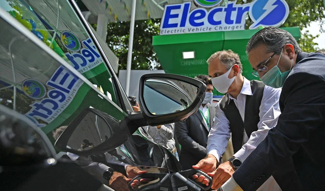 Pakistan's energy minister Omar Ayub Khan and Prime Minister's advisor on Petroleum Nadeem Babar charge an electric car during the inauguration ceremony of country's first electric vehicle charging station, in Islamabad on July 29, 2020. (AFP/File)