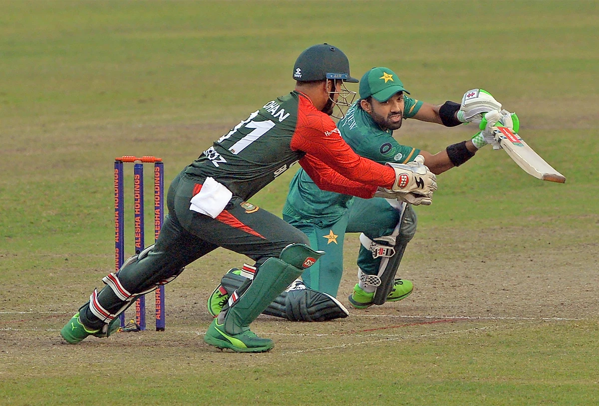Pakistan's Mohammad Rizwan (R) plays a shot as Bangladesh's wicketkeeper Nurul Hasan tries to catch the ball during the third Twenty20 cricket match at Sher-E-Bangla National Cricket Stadium in Dhaka on November 22, 2021. (AFP)