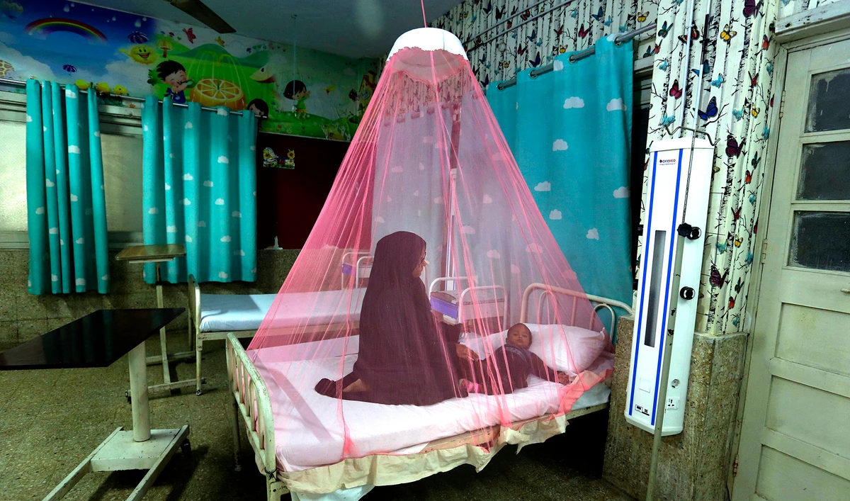 A mother takes care of her son who is suffering from dengue fever in a hospital in Karachi, Pakistan, on November 22, 2021. (AP)