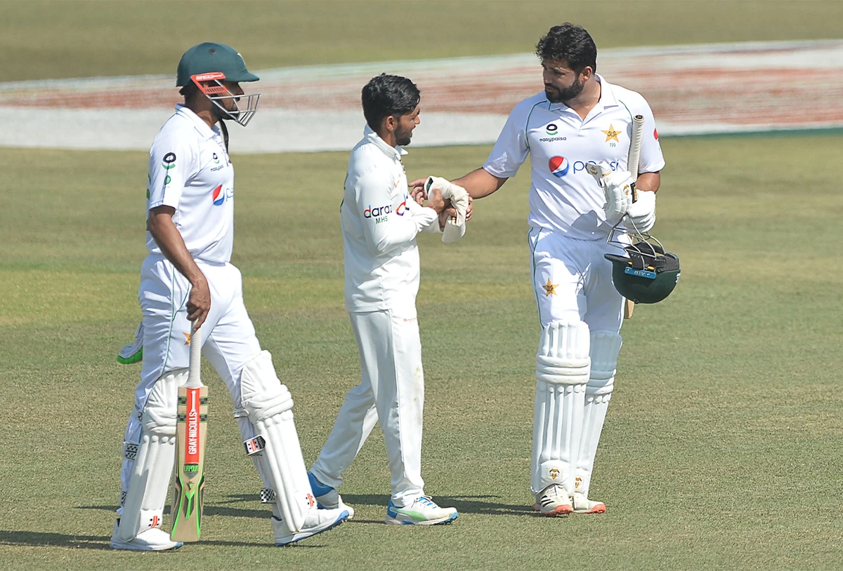 Pakistan's Azhar Ali (R) shakes hands with Bangladesh's captain Mominul Hoque (C) as Pakistan's captain Babar Azam (L) looks on at the end of the first Test cricket match between Bangladesh and Pakistan in Chittagong on November 30, 2021. (AFP)