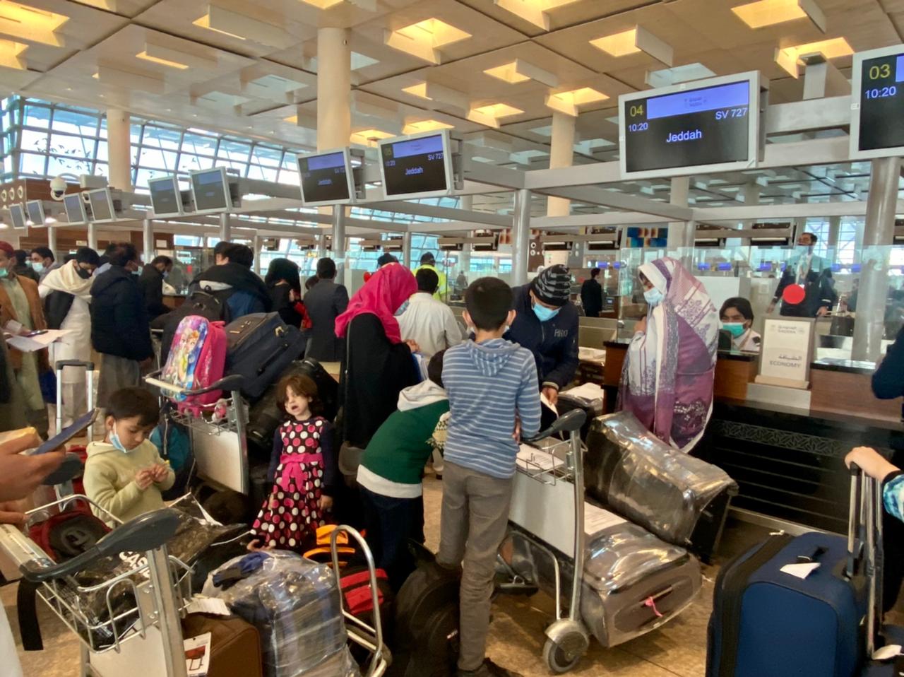 Saudi airlines officials issue boarding passes to passengers of the first flight to Jeddah at the Islamabad International Airport in Islamabad, Pakistan on December 1, 2021, after the kingdom removes a travel ban on Pakistan. (AN Photo)