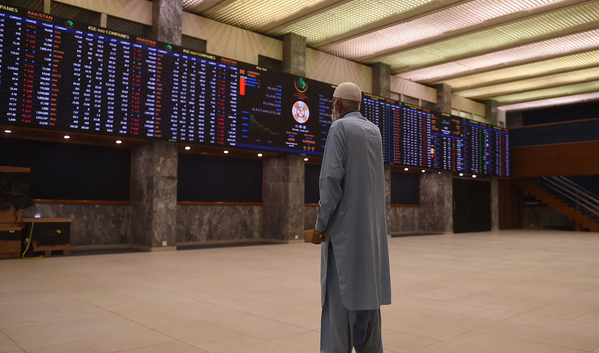 A stockbroker looks at share prices on an index board during a trading session at the Pakistan Stock Exchange (PSX) in Karachi on December 2, 2021. (AFP)