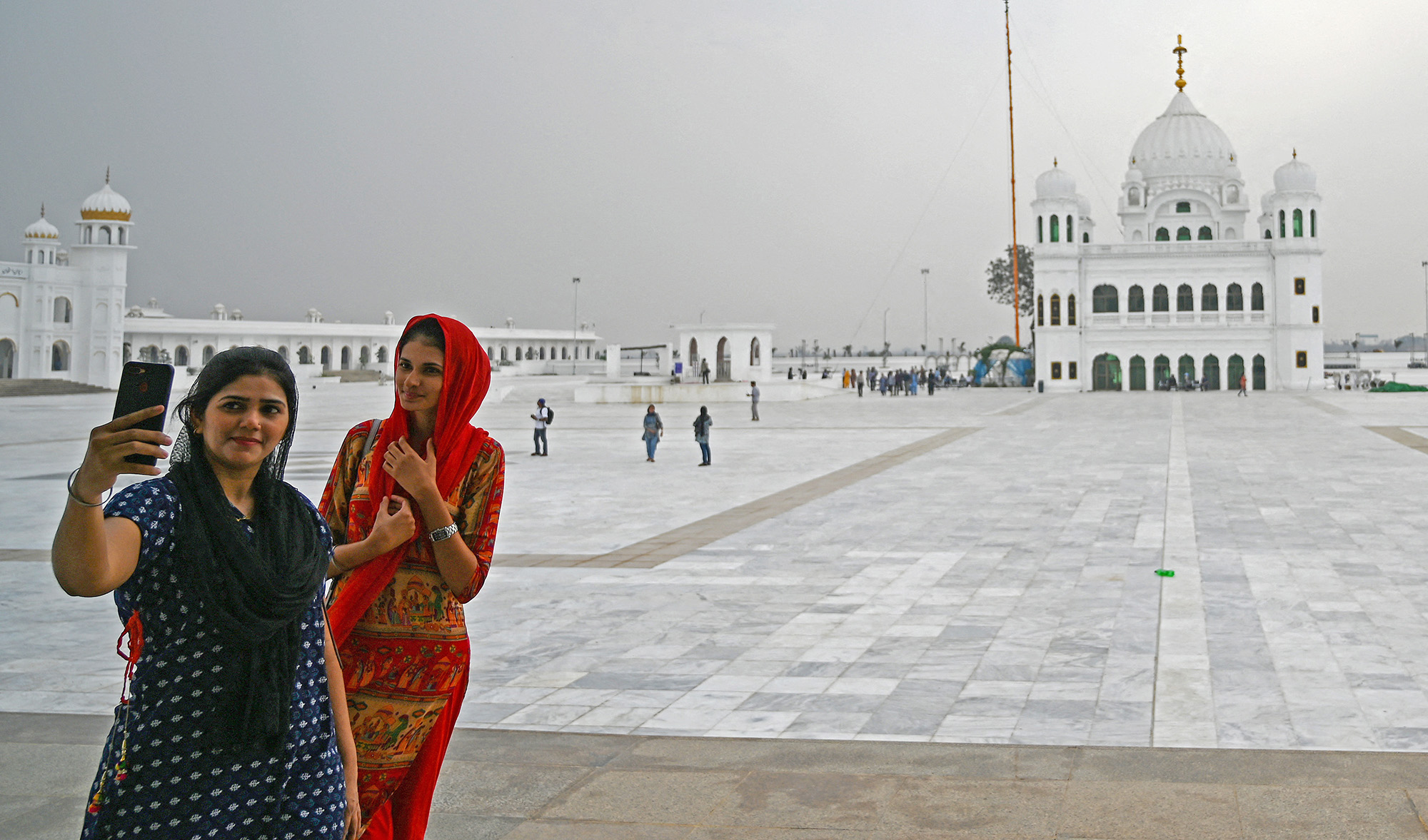 Sikh pilgrims take selfie pictures in front of the Shrine of Baba Guru Nanak Dev at the Gurdwara Darbar Sahib in the Pakistani town of Kartarpur on November 6, 2019. (AFP/File)
