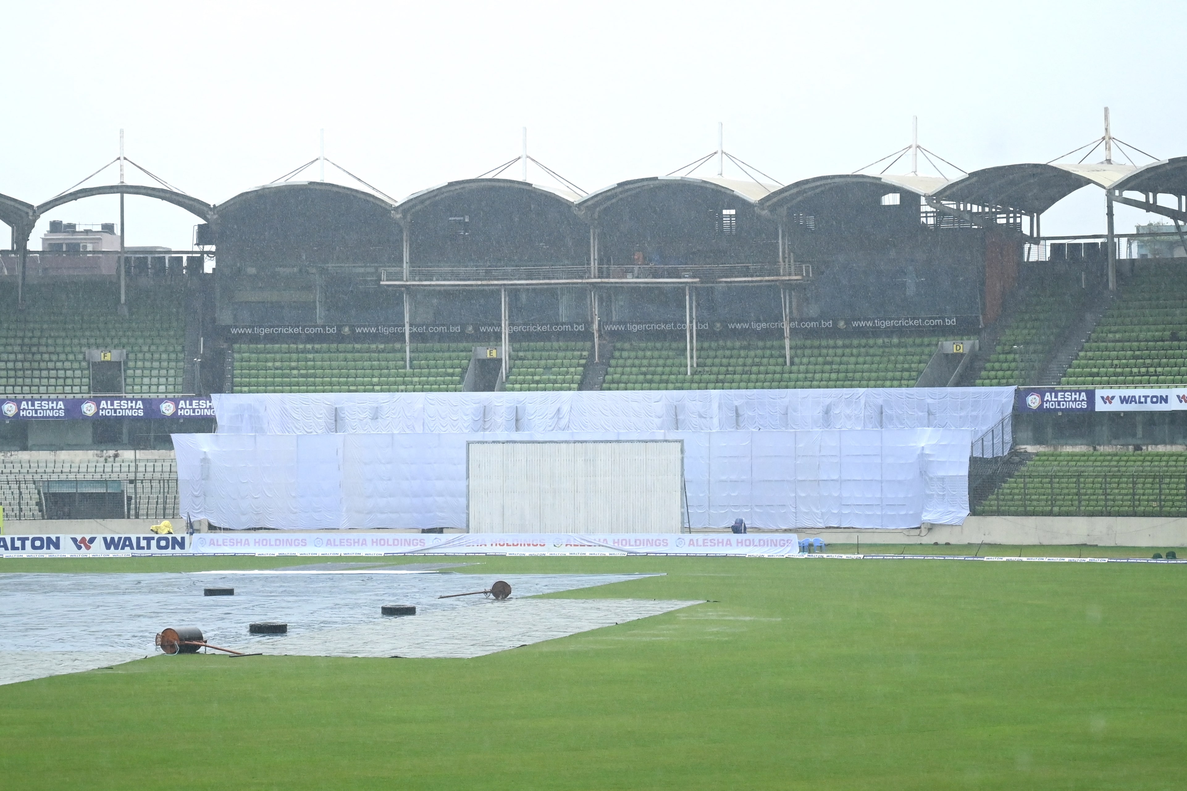 The pitch is covered with plastic sheets as rain interrupts the third day play of the second Test cricket match between Bangladesh and Pakistan at the Sher-e-Bangla National Cricket Stadium in Dhaka on December 6, 2021. (AFP)