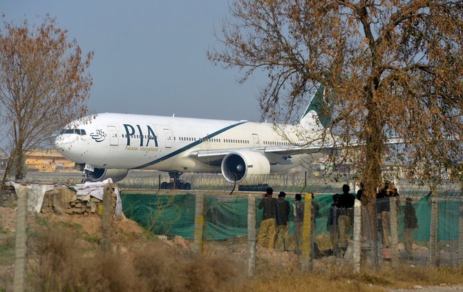 Pakistan policemen stand guard as a Pakistan International Airline (PIA) plane taxis on the runway on the way to Saudi Arabia during the PIA employees strike in Islamabad on February 8, 2016. (AFP/ File)