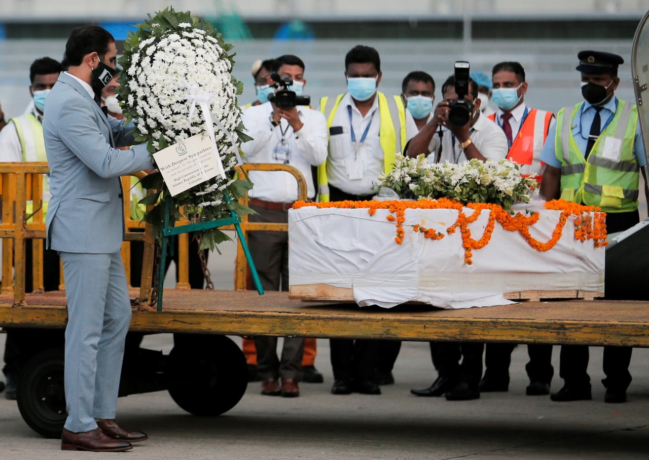A representative from Pakistan High Commission to Sri Lanka places a flower wreath next to the coffin with remains of Sri Lankan national Priyantha Kumara, who was beaten to death and burnt by the mob in Punjab province on last Friday, at Bandaranaike International Airport, in Katunayake, Sri Lanka December 6, 2021. (REUTERS)