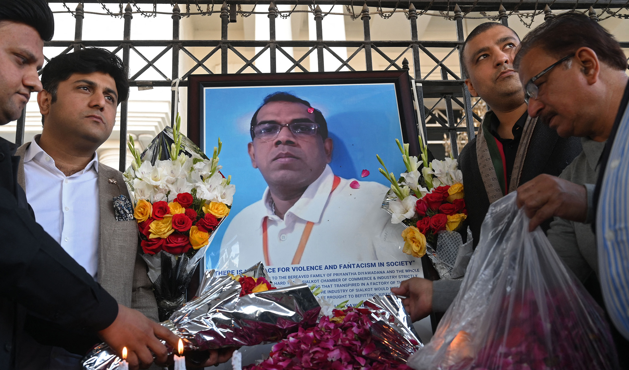 Pakistani industrialists pay tribute beside a photograph of late Sri Lankan factory manager, in Sialkot on December 4, 2021, after he was beaten to death and set ablaze by a mob blasphemy suspicion. (AFP/File)