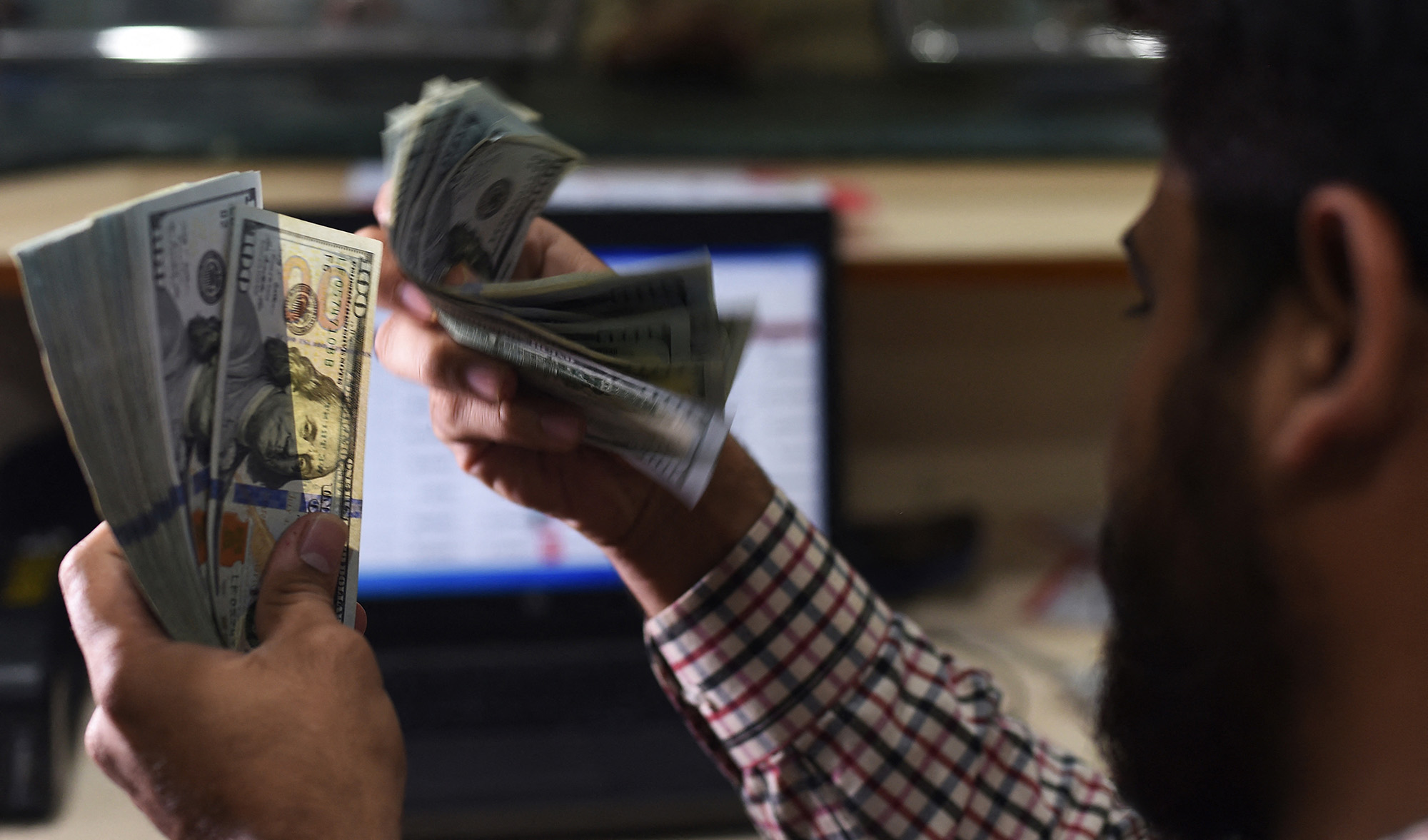 A Pakistani dealer counts US dollars at a currency exchange shop in Karachi, Pakistan, on October 9, 2018. (AFP/File)
