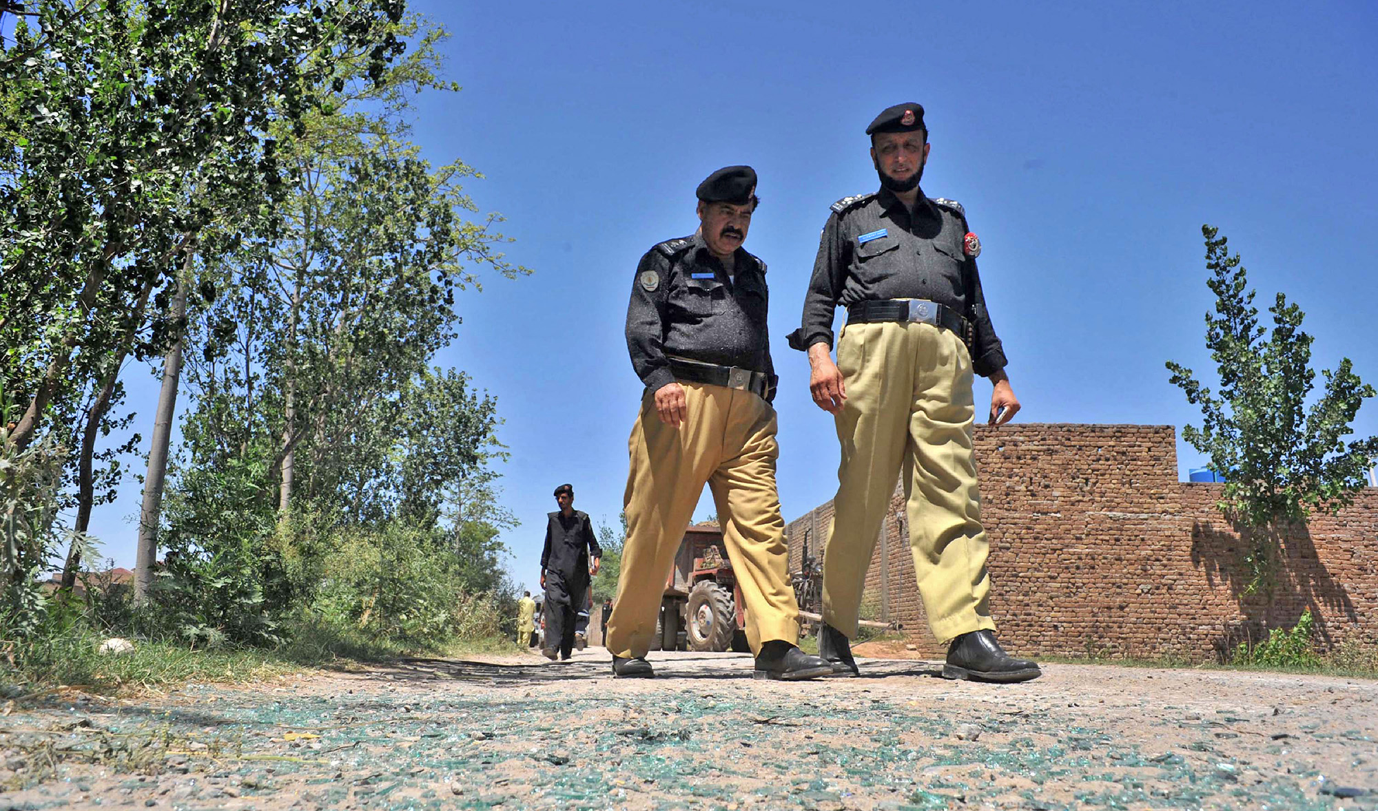 Pakistani police officials inspect the site of a roadside bomb explosion in Peshawar, Pakistan, on May 18, 2016. (AFP/File)