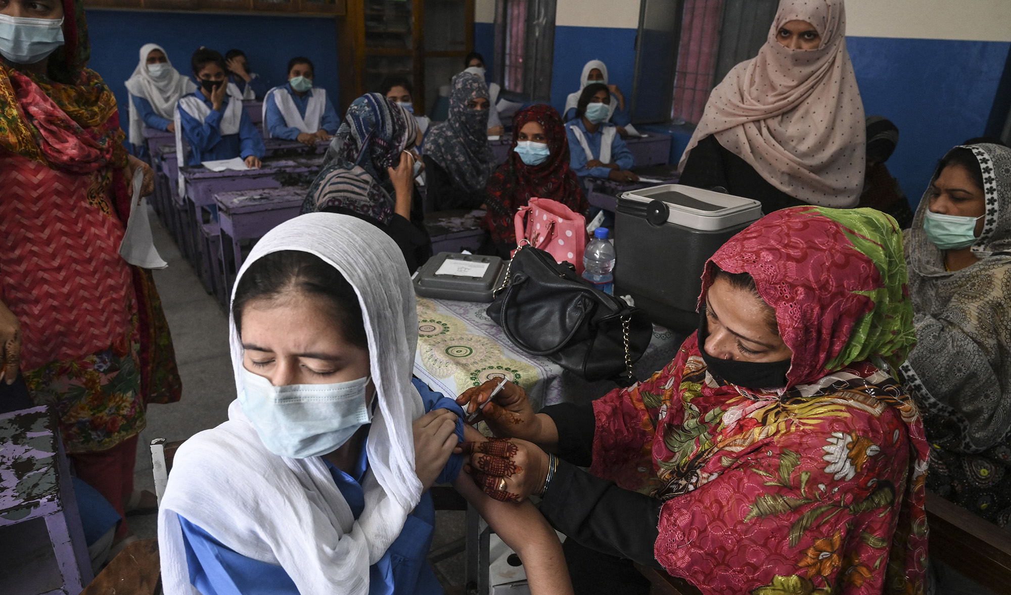 A health worker inoculates a student with a dose of Pfizer vaccine against the COVID-19 coronavirus at a school in Lahore, Pakistan, on October 5, 2021. (AFP/File)