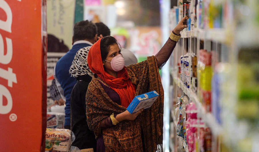 A woman wearing a facemask buys grocery items from a state-run utility store in Islamabad, Pakistan on March 17, 2020. (AFP/File)