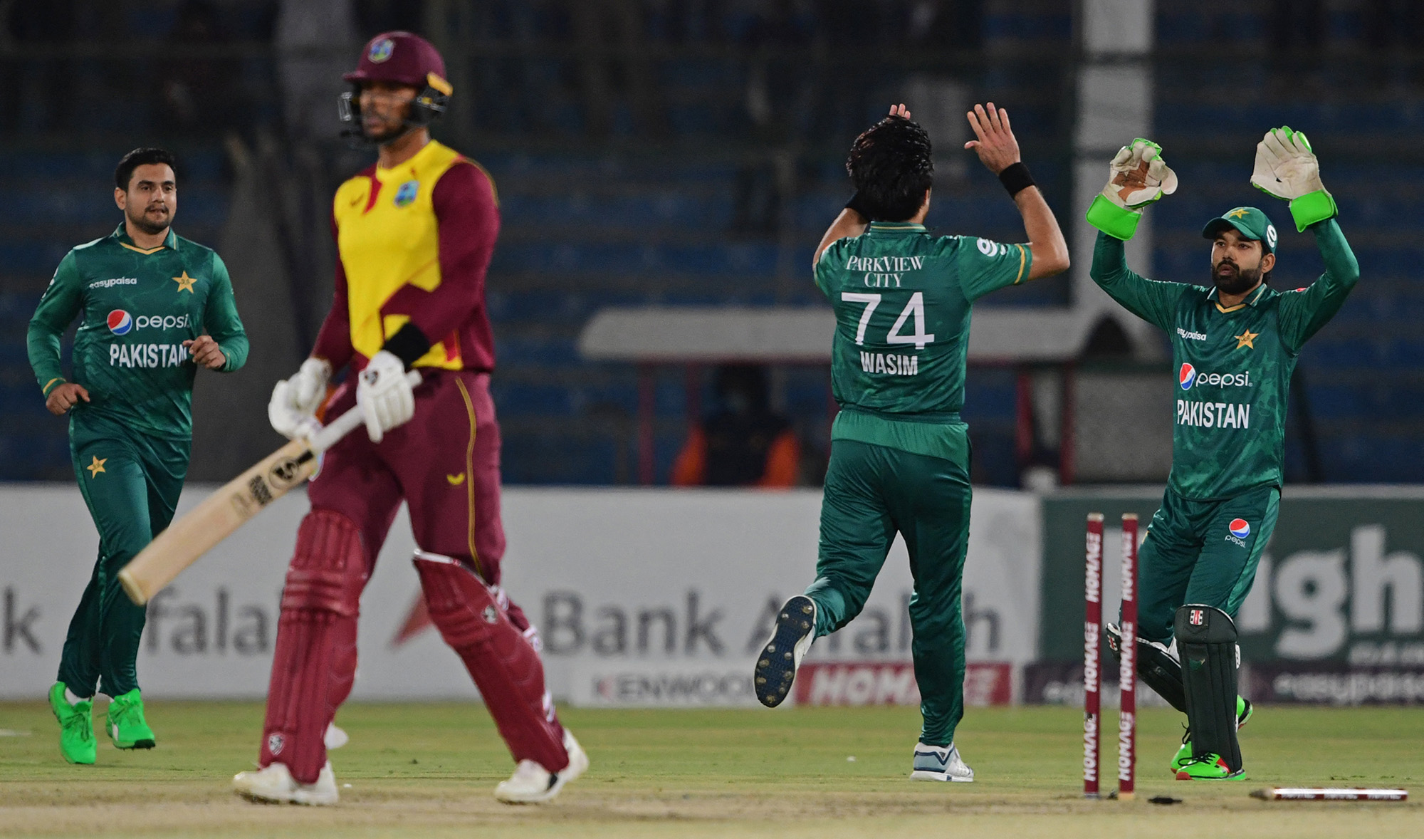 Pakistan's Mohammad Wasim, second right, celebrates with teammates after taking the wicket of West Indies' Brandon King, second left, during the third T20 cricket match at the National Stadium in Karachi on December 16, 2021. (AFP)