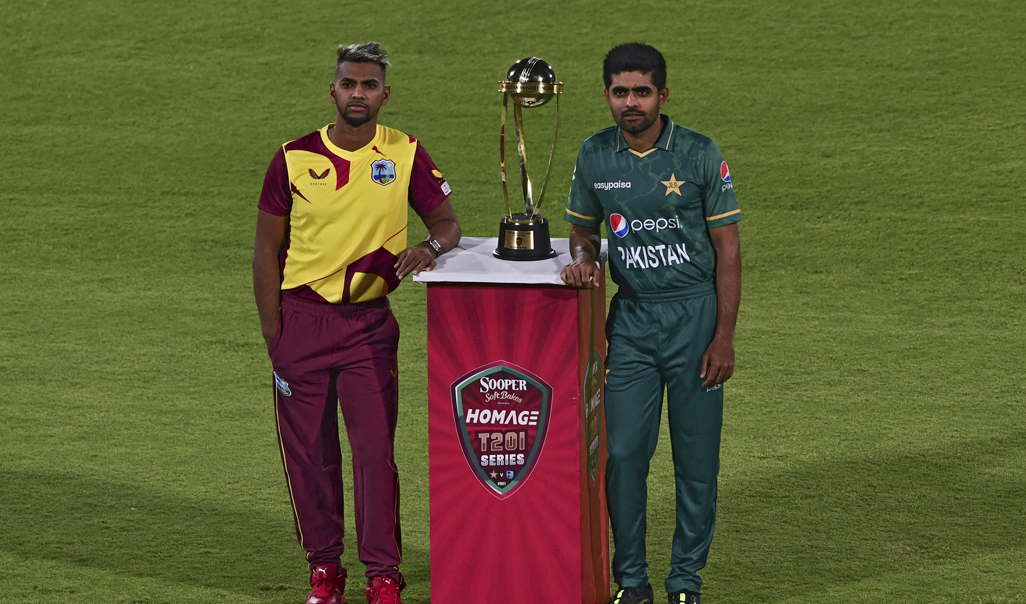 West Indies' captain Nicholas Pooran, left, and Pakistan's captain Babar Azam pose with the T20 trophy before the start of a practice session at the National Stadium in Karachi on December 12, 2021. (AFP)