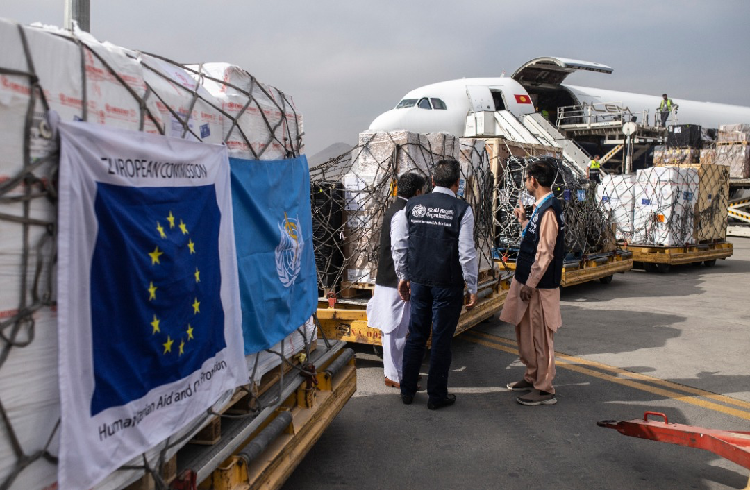 The picture shows workers standing with the supplies from 10th EU Humanitarian Air Bridge flight for Afghanistan, a joint effort by the European Union, WHO and World Vision, that landed in Kabul, Afghanistan, on December 13, 2021. (Photo Courtesy: EU ECHO)
