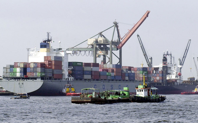 Pakistani vessels pass by container ships being loaded with cargo at the port of Karachi, Sept.8, 2003. (AFP/File)