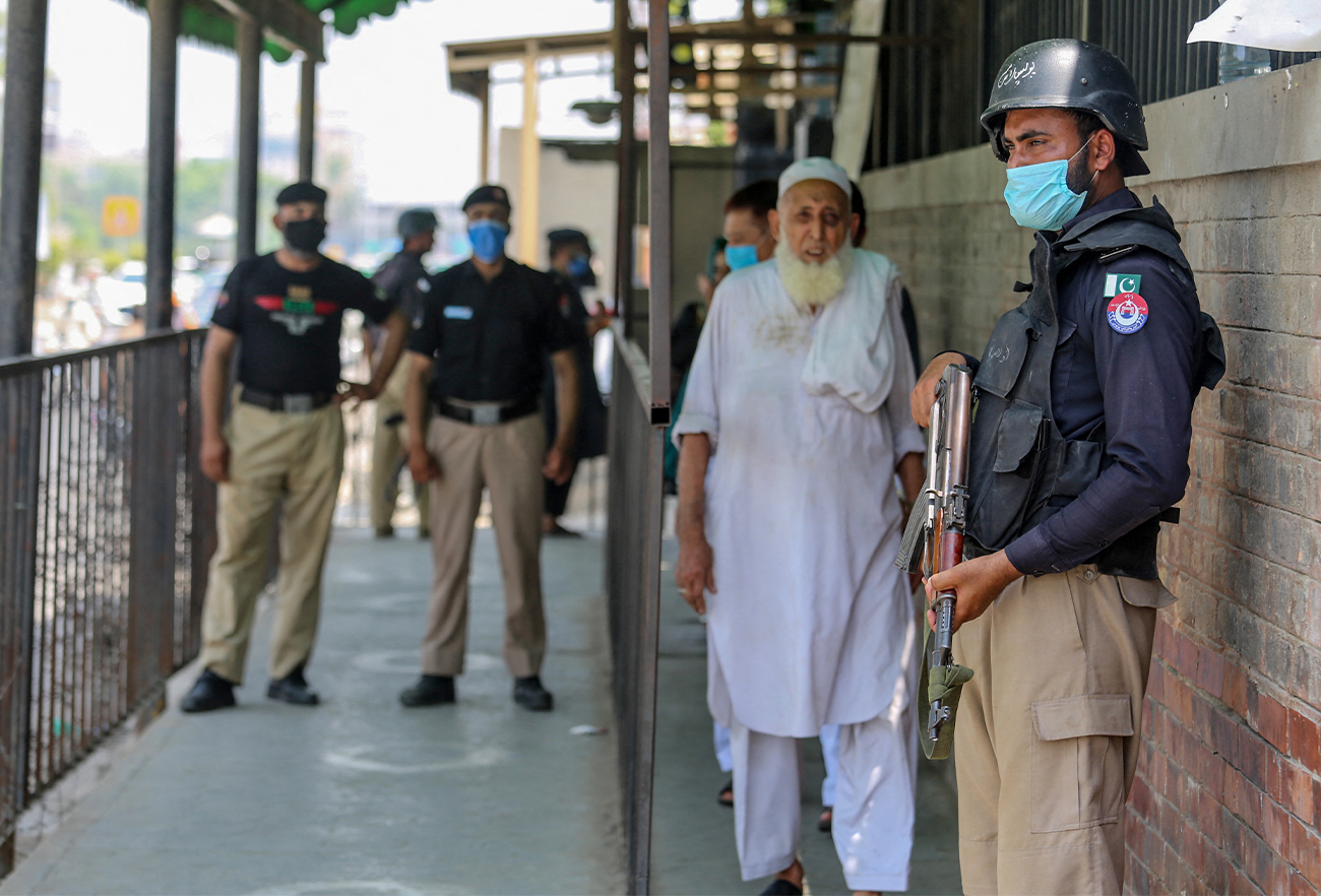 Security personnel (L and R) stand guard outside the district court building following the killing of a man in Peshawar, Pakistan, on July 29, 2020. (AFP/File)