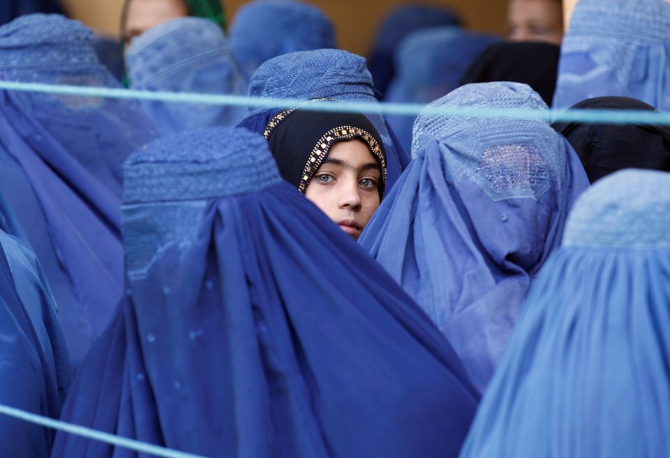 A girl looks on among Afghan women lining up to receive relief assistance, during the holy month of Ramadan in Jalalabad, Afghanistan, June 11, 2017. (REUTERS)