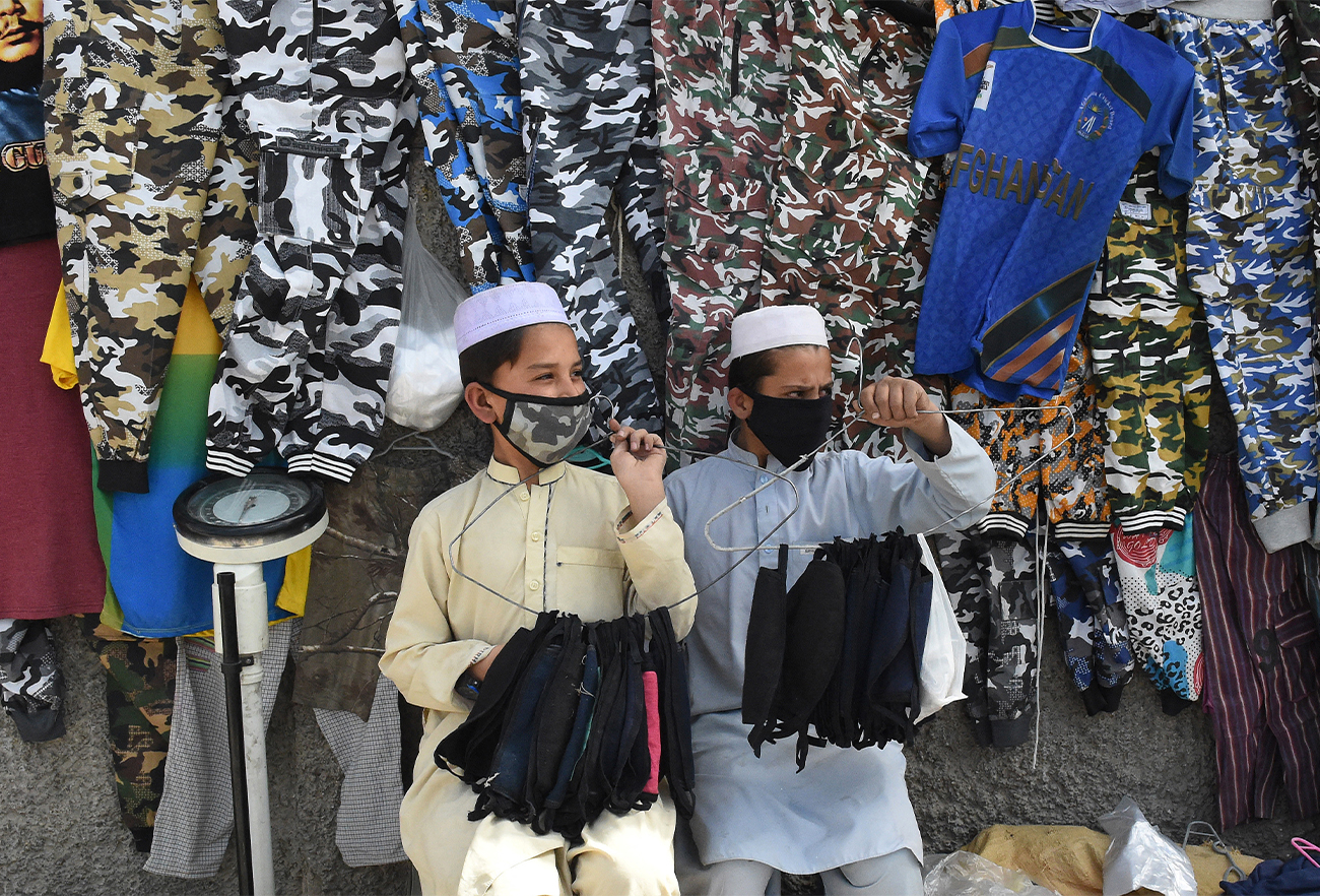 Facemasks vendors wear protective facemasks as a prevention measure against the coronavirus alongside a street in Quetta, Pakistan, on February 27, 2020. (AFP/File)