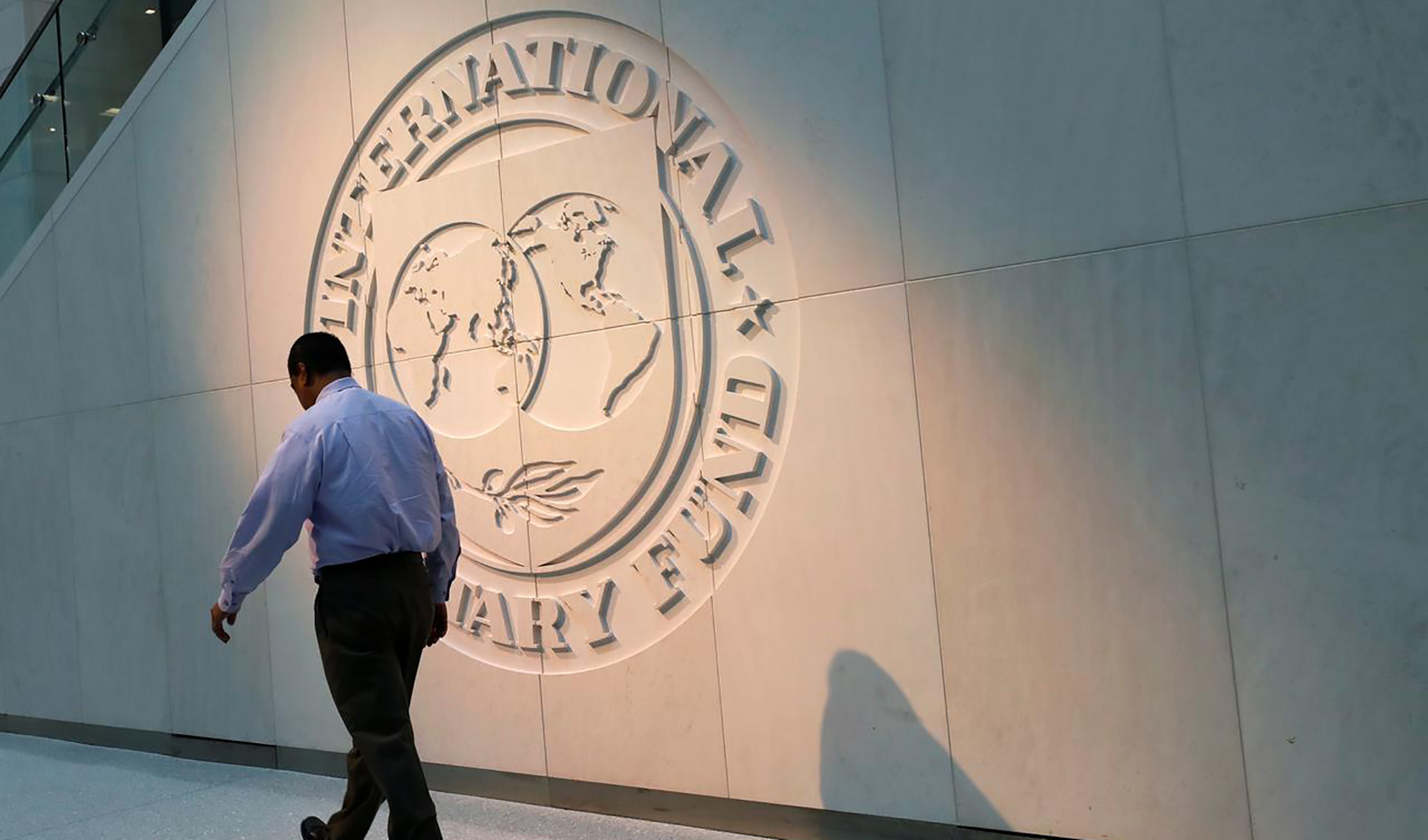 A man walks past the International Monetary Fund (IMF) logo at its headquarters in Washington, US, on May 10, 2018. (REUTERS/File)