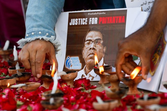 People light oil lamps next to laid roses to express their condolences to the people of Sri Lanka, following the lynching of the Sri Lankan manager of a Sialkot garment factory, in Karachi, Pakistan on December 5, 2021. (Photo courtesy: Reuters)