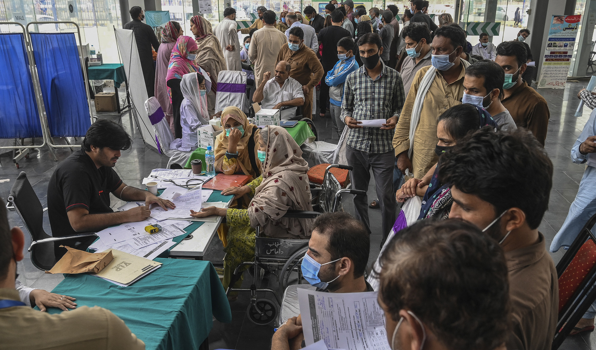 Relatives of patients infected with dengue crowd at the admission counter for bed allocation at a dengue ward in a hospital in Lahore, Pakistan, on October 17, 2021. (AFP/File)