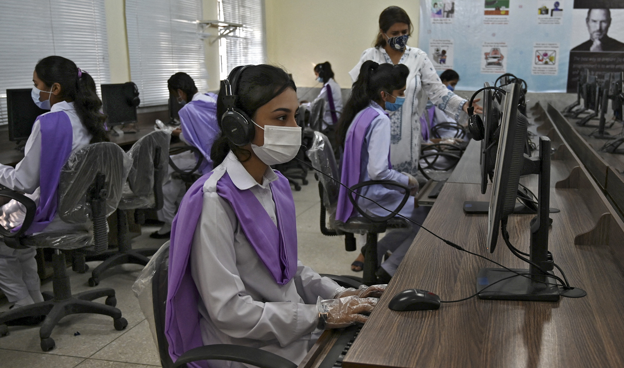 Students wearing facemasks attend a computer class at the Islamabad Model College of Commerce for Girls in Islamabad, Pakistan, on September 15, 2020. (AFP/File)
