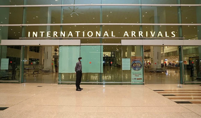 Airport Security Force (ASF) personnel wearing a mask stand guard at the International arrivals area at Islamabad International Airport, Pakistan, on May 5, 2020. (Photo courtesy: Ministry of Overseas Pakistanis & HRD/Twitter)