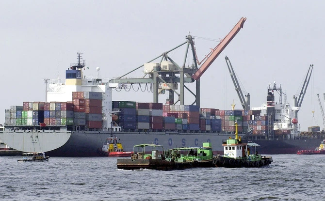 Pakistani vessels pass by container ships being loaded with cargo at the port of Karachi, Sept.8, 2003. (AFP/File)