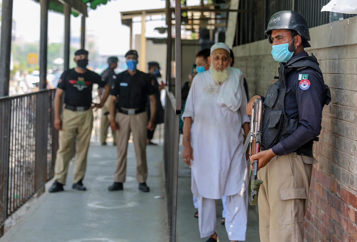 Security personnel (L and R) stand guard outside the district court building following the killing of a man in Peshawar, Pakistan, on July 29, 2020. (AFP/File)
