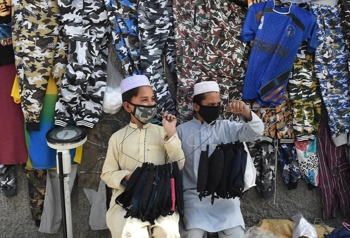 Facemasks vendors wear protective facemasks as a prevention measure against the coronavirus alongside a street in Quetta, Pakistan, on February 27, 2020. (AFP/File)