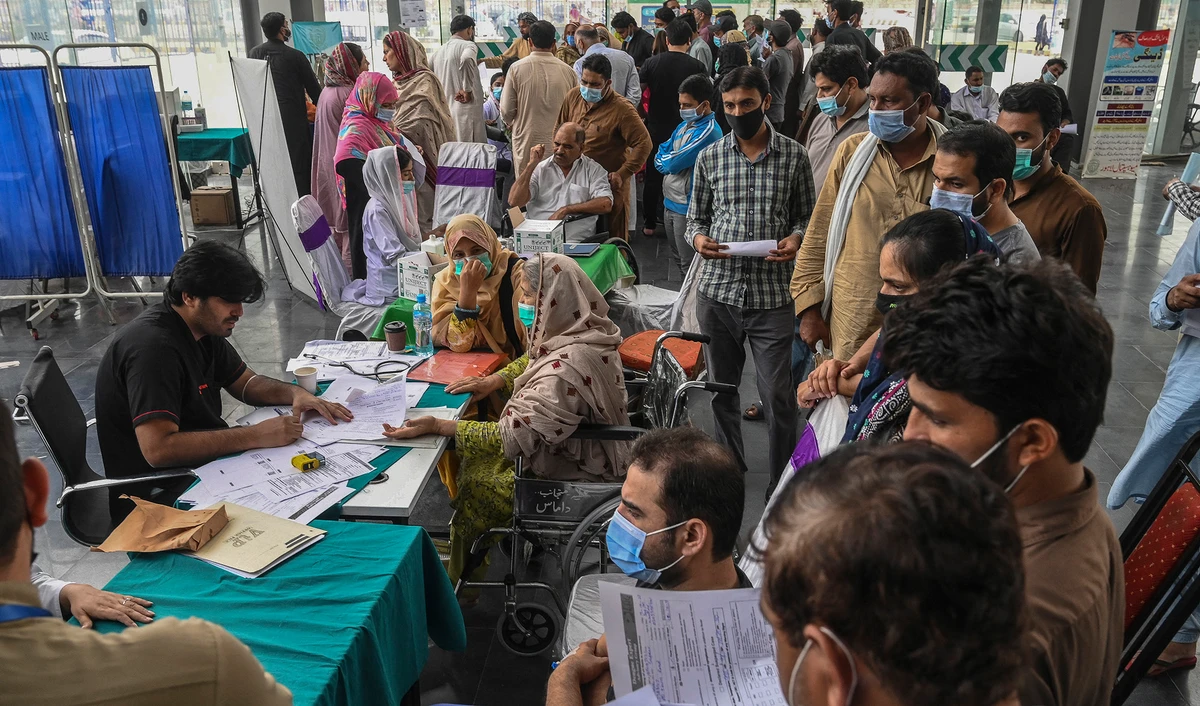 Relatives of patients infected with dengue crowd at the admission counter for bed allocation at a dengue ward in a hospital in Lahore, Pakistan, on October 17, 2021. (AFP/File)