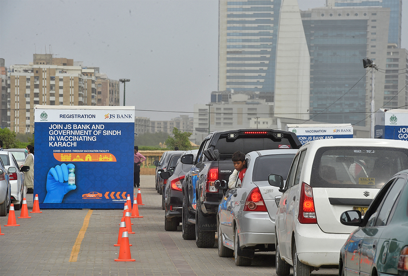 People queue up in their cars to receive a dose of the Sinopharm vaccine against the coronavirus, during a drive-through vaccination in Karachi, Pakistan, on July 26, 2021. (AFP/File)