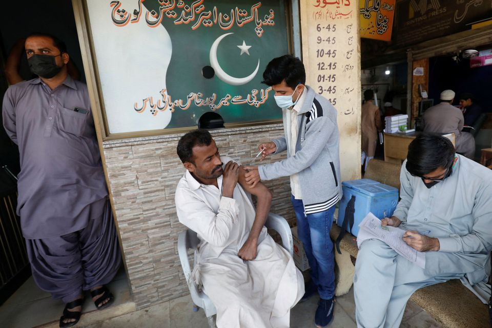 A man receives a dose of the coronavirus disease (COVID-19) vaccine at a market in Karachi, Pakistan, December 16, 2021. (REUTERS)