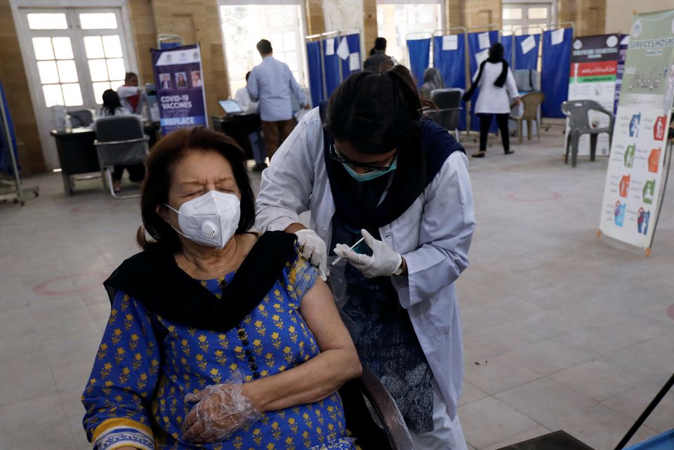 A woman receives the first dose of the coronavirus disease (COVID-19) vaccine, as the government started vaccination for the general public, starting with elderly people, at a vaccination center in Karachi, Pakistan March 10, 2021. (REUTERS)