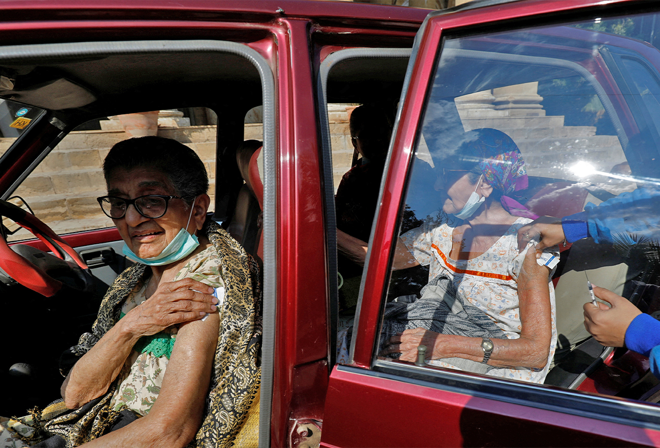 Women receive coronavirus disease booster vaccine outside a vaccination centre in Karachi, Pakistan, on January 7, 2022. (REUTER)