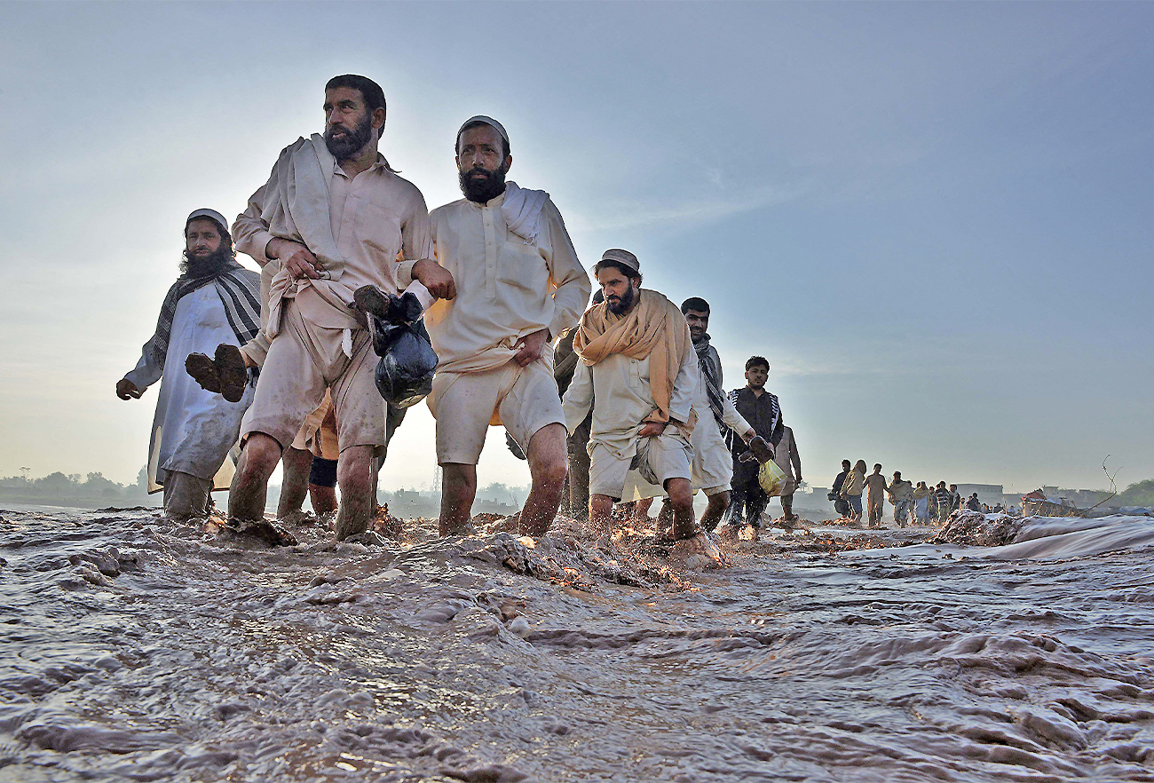 Pakistani residents cross a flooded street following heavy rain on the outskirts of Peshawar, Pakistan, on April 4, 2016. (AFP/File)