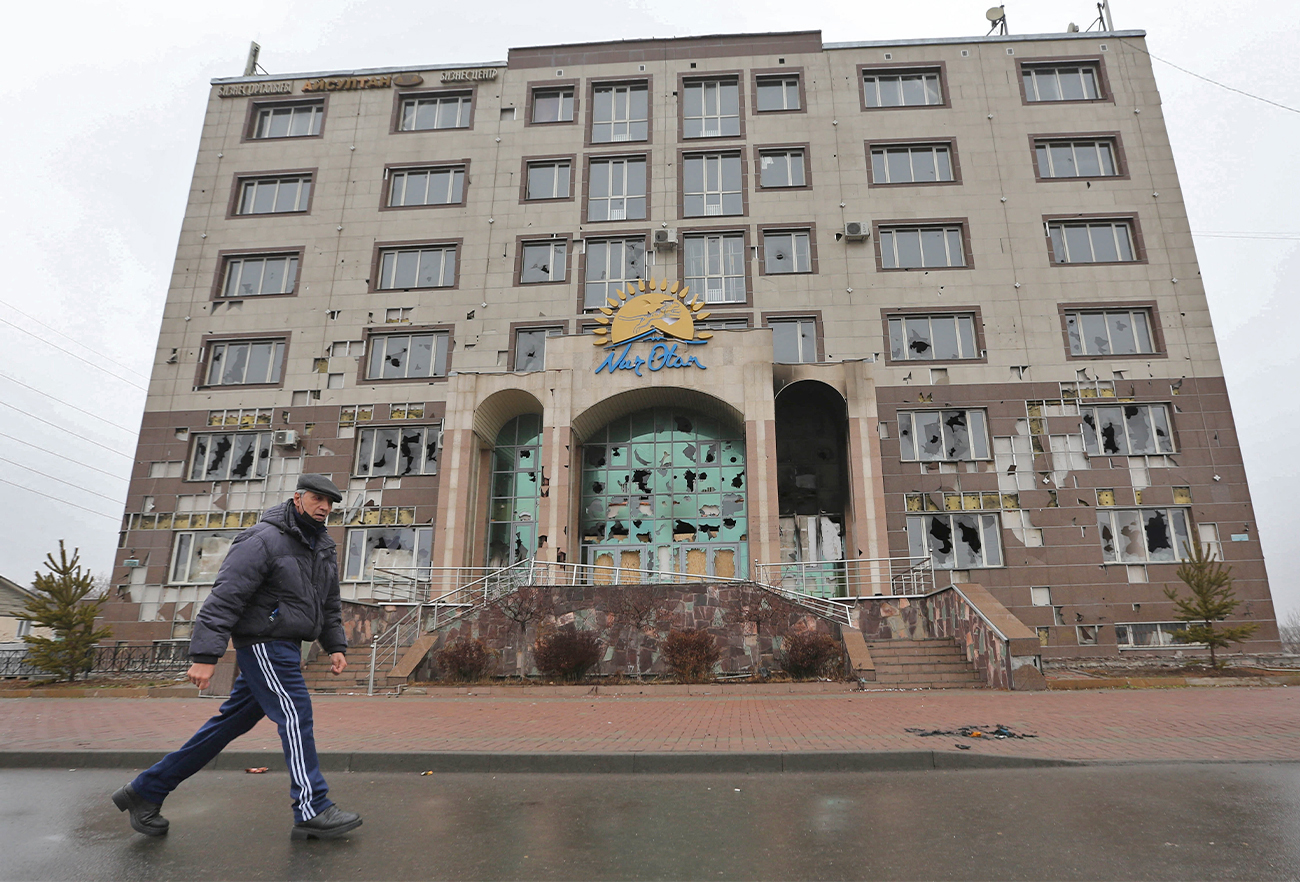 A man walks past the office building of the Nur Otan ruling party, which was damaged during mass protests triggered by fuel price increase, in Almaty, Kazakhstan, on January 8, 2022. (REUTERS)