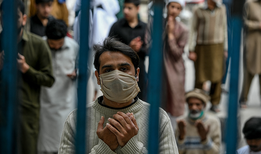 A Muslim worshipper wearing a facemask prays during Friday prayers outside the closed gate of Jamia Mosque in Rawalpindi on April 3, 2020. (AFP/FILE)