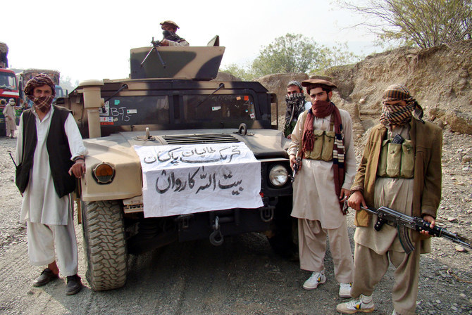 Armed militants of Tehreek-e-Taliban Pakistan (TTP) pose for photographs next to a captured armored vehicle in the Pakistan-Afghanistan border town of Landikotal on November 10, 2008. (AFP/FILE)